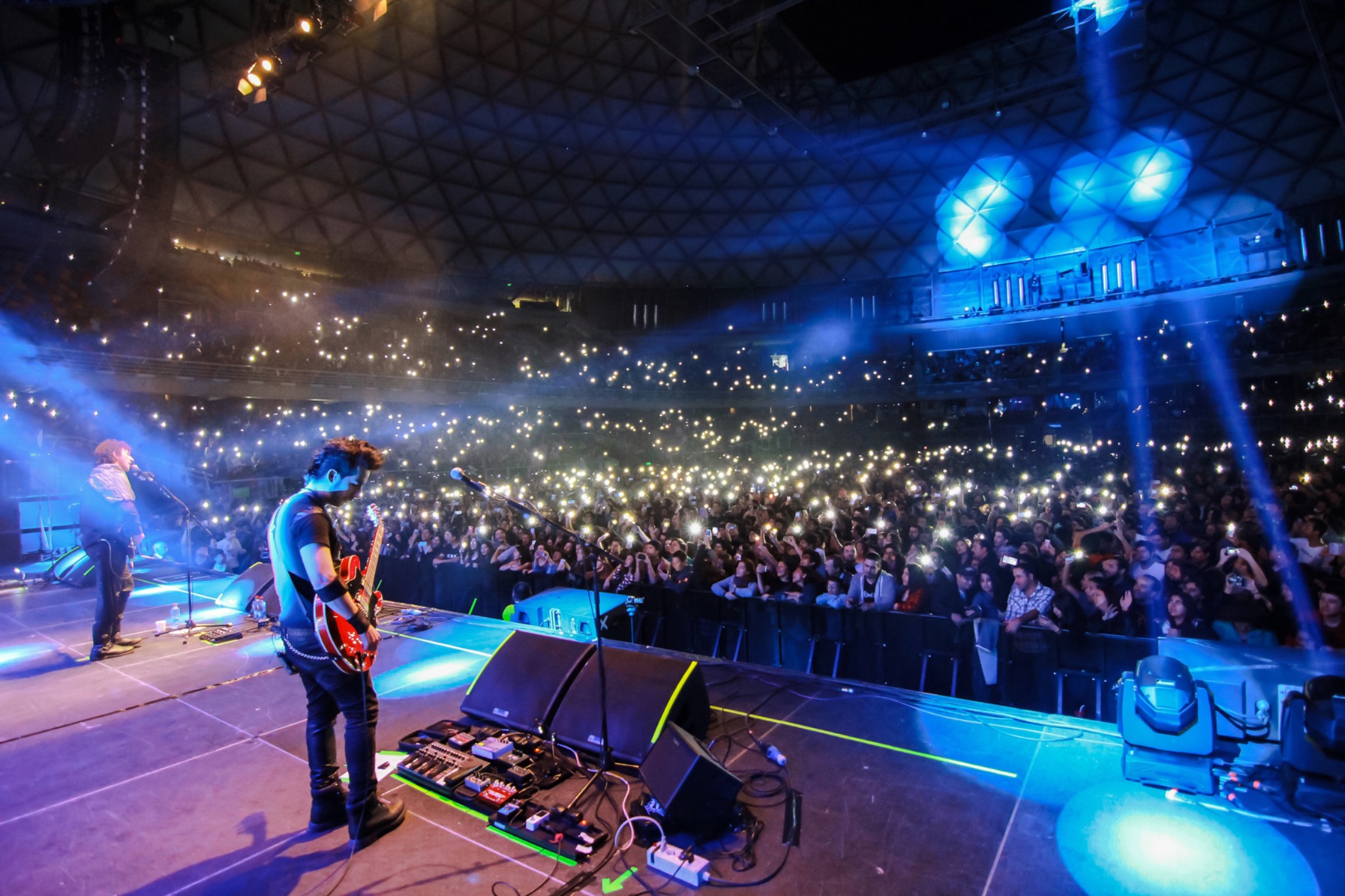 PROFUGOS frente al público del Movistar Arena iluminado por miles de teléfonos